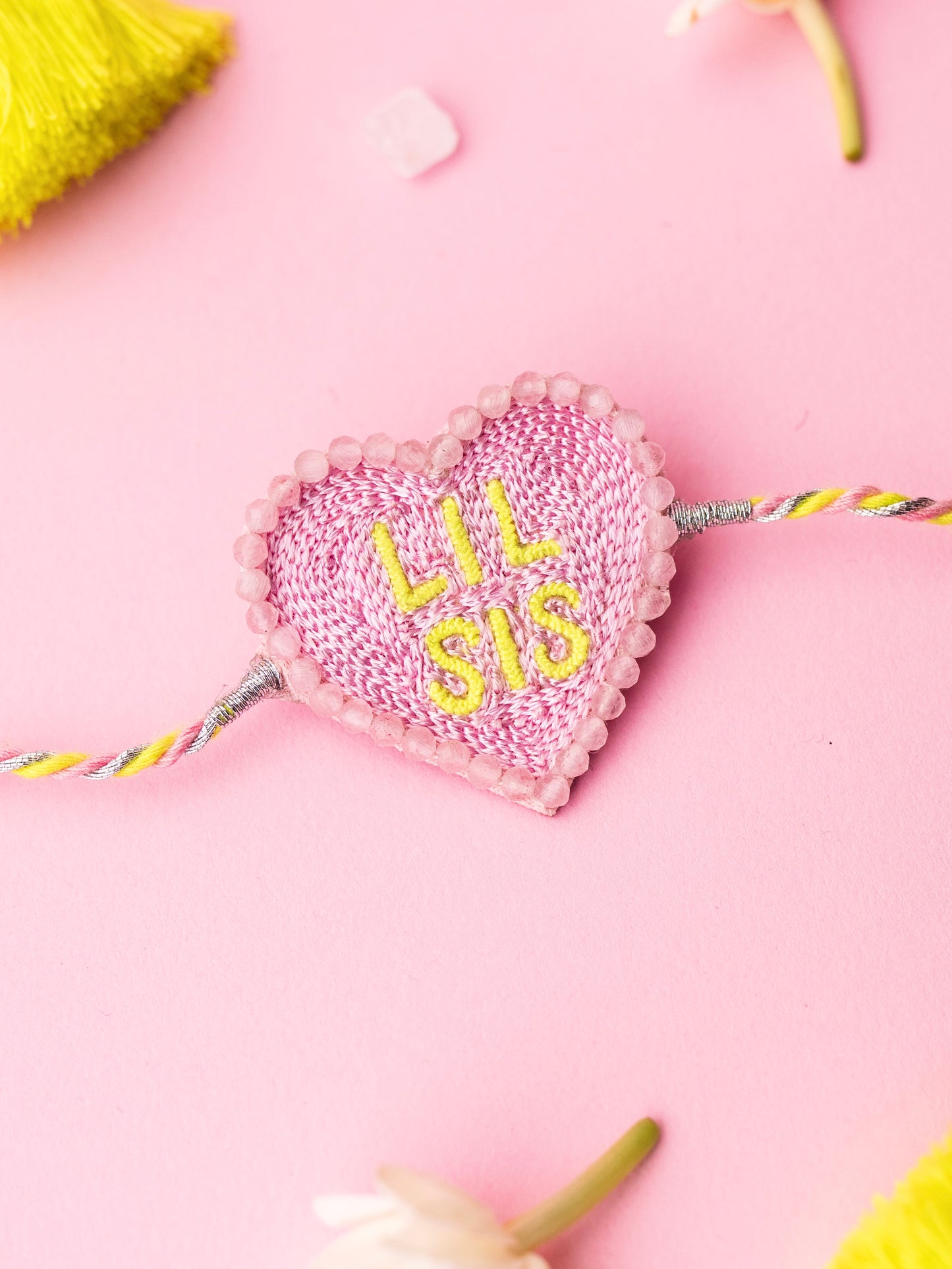 Decorative sister rakhi with heart-shaped lil sis text