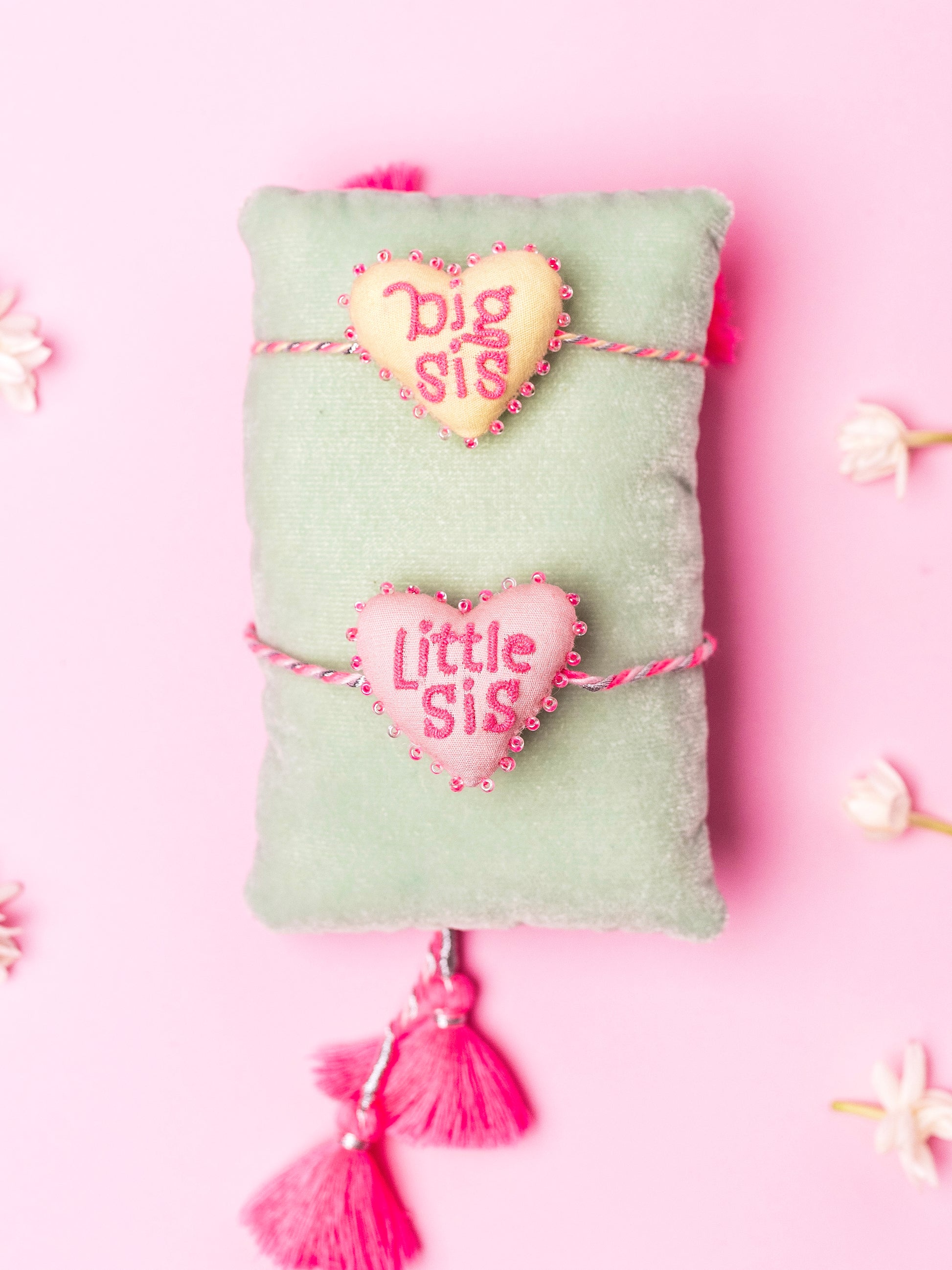 Decorative pink sister rakhi combo with heart-shaped 3D big sis and little sis text