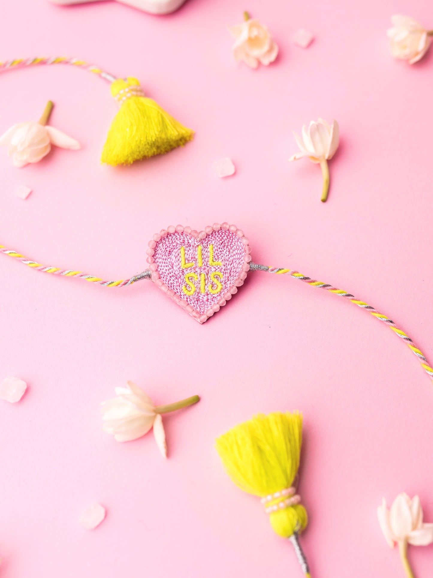 Decorative sister rakhi with heart-shaped lil sis text