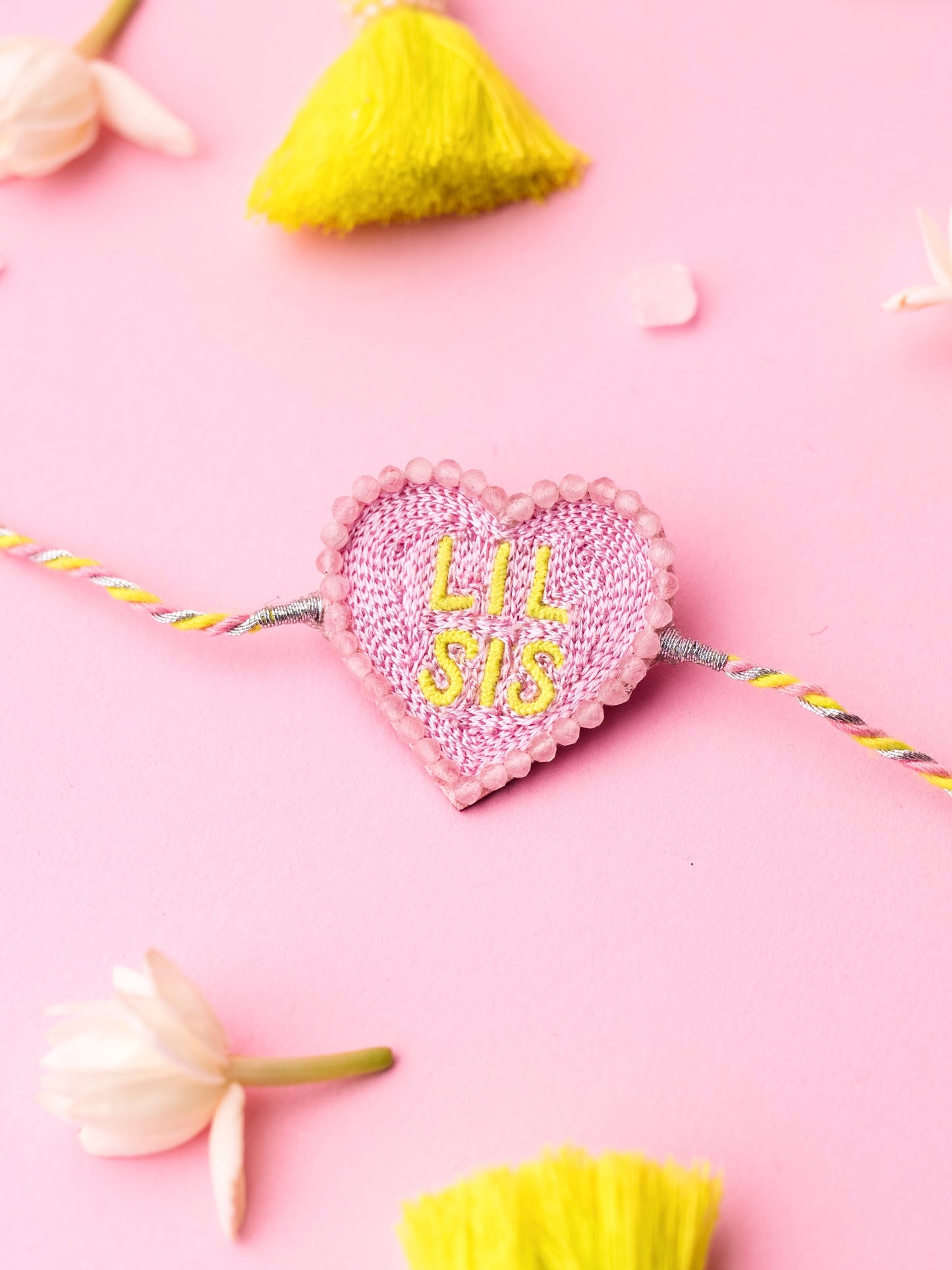 Decorative sister rakhi with heart-shaped lil sis text