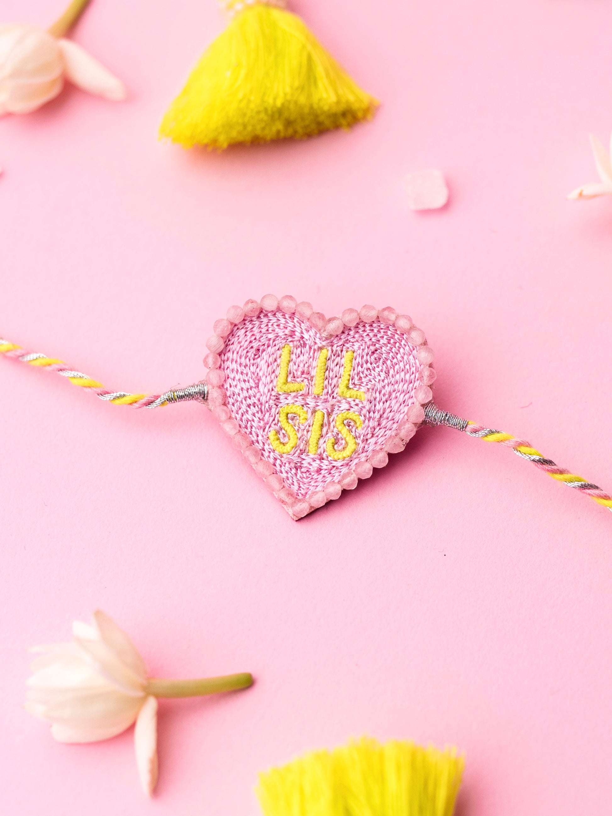 Decorative sister rakhi with heart-shaped lil sis text