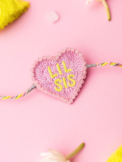 Decorative sister rakhi with heart-shaped lil sis text
