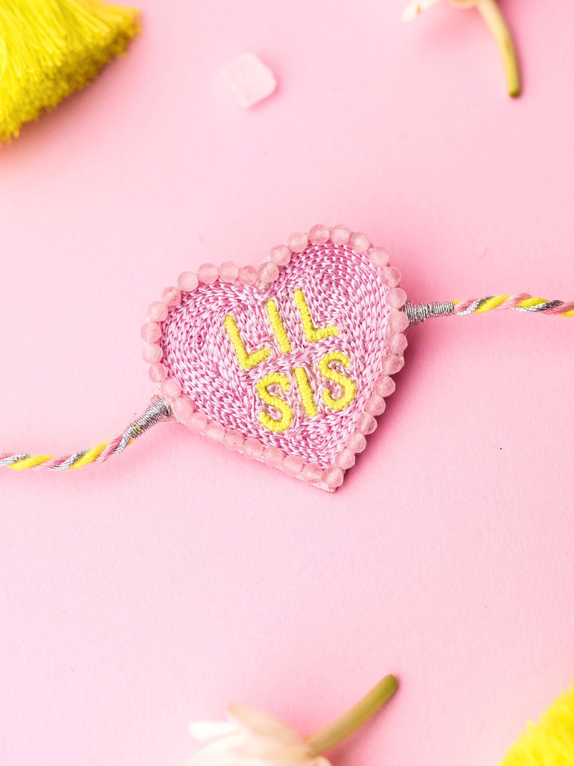 Decorative sister rakhi with heart-shaped lil sis text