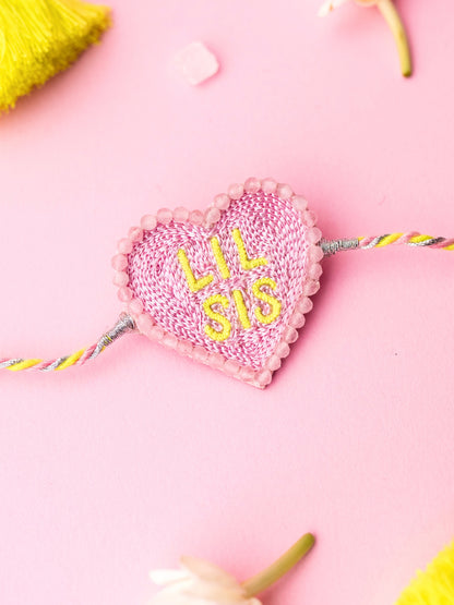 Decorative sister rakhi with heart-shaped lil sis text