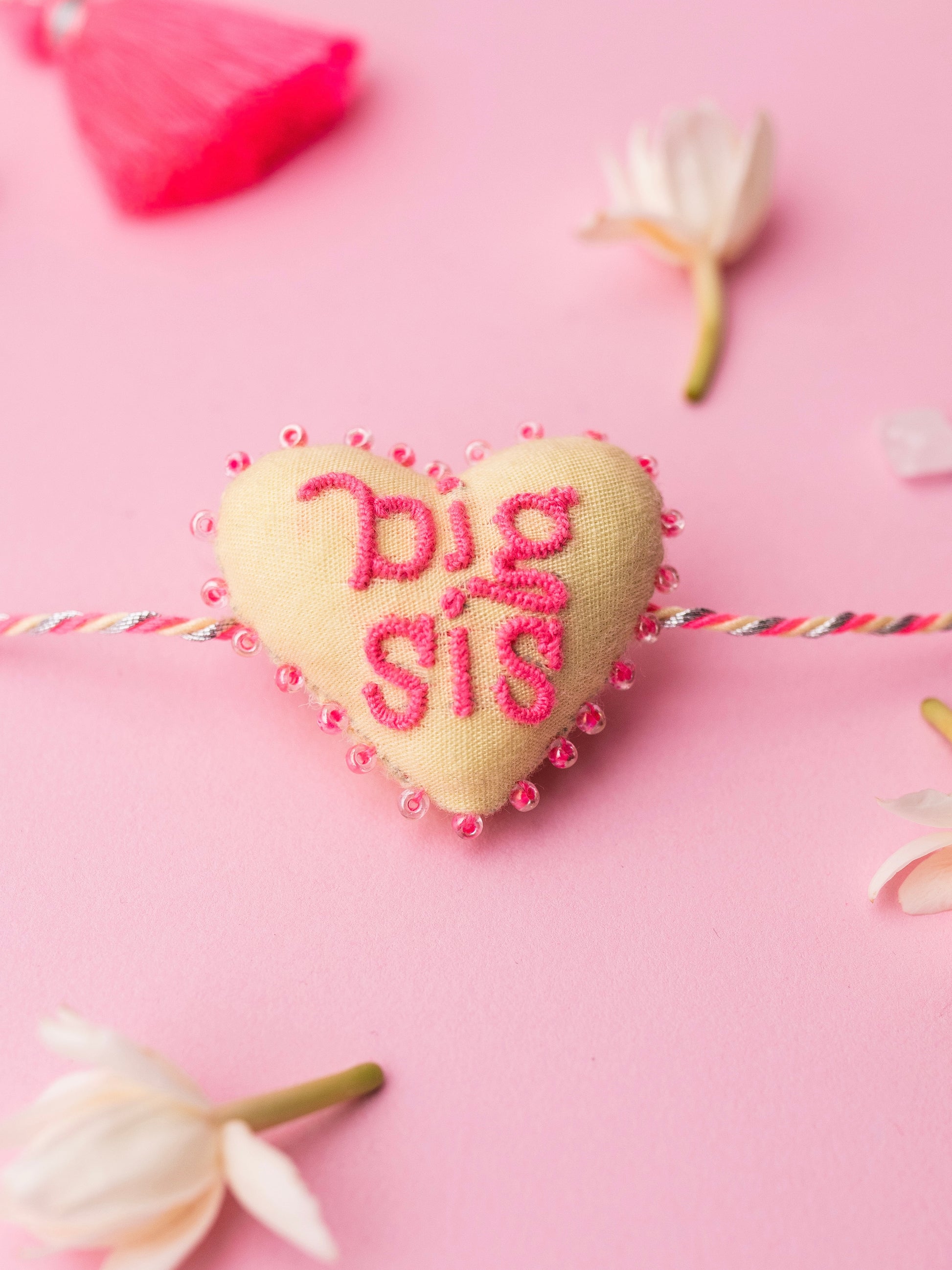Decorative pink sister rakhi with heart-shaped 3D big sis text
