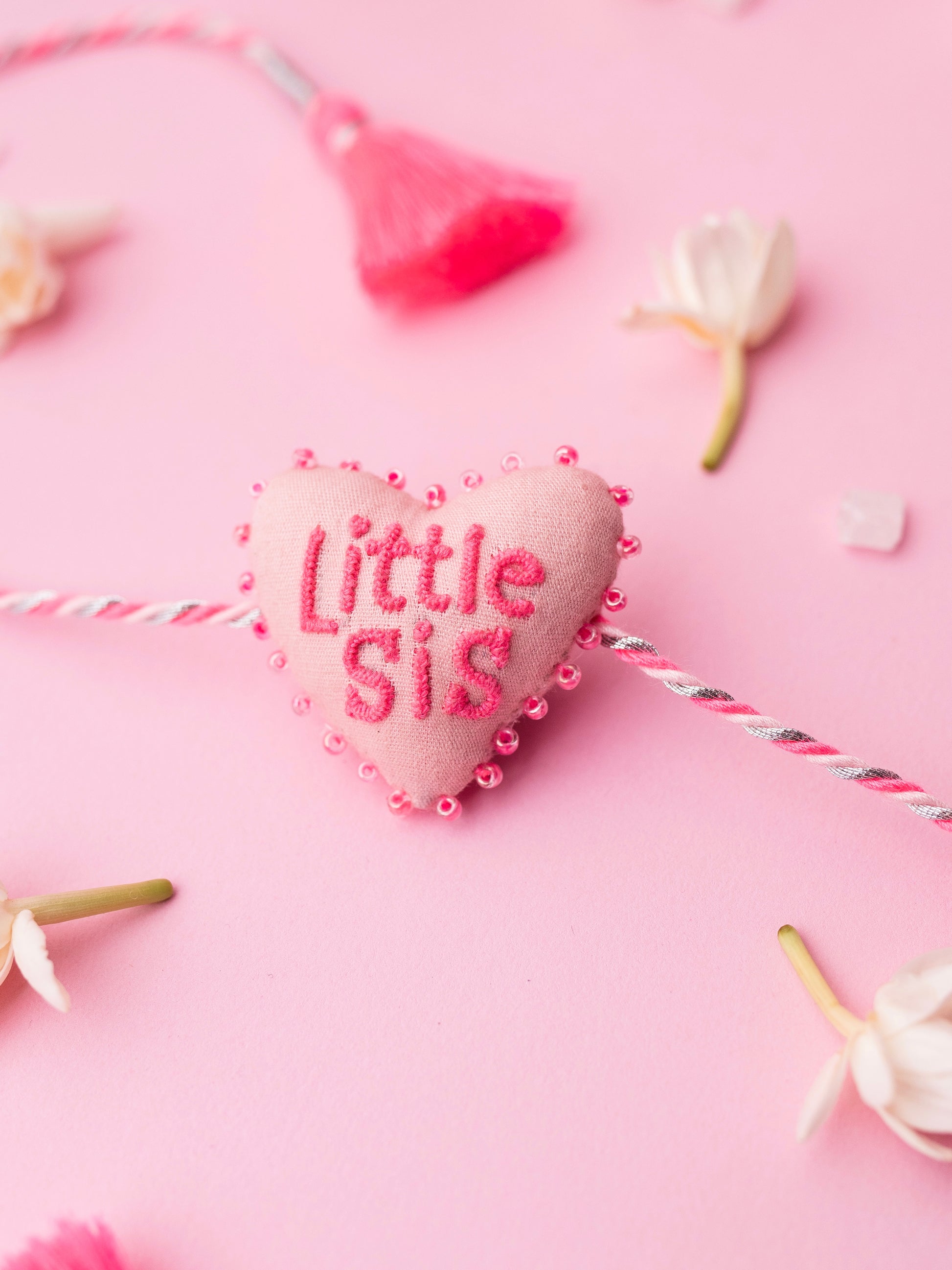 Decorative pink sister rakhi with heart-shaped 3D little sis text