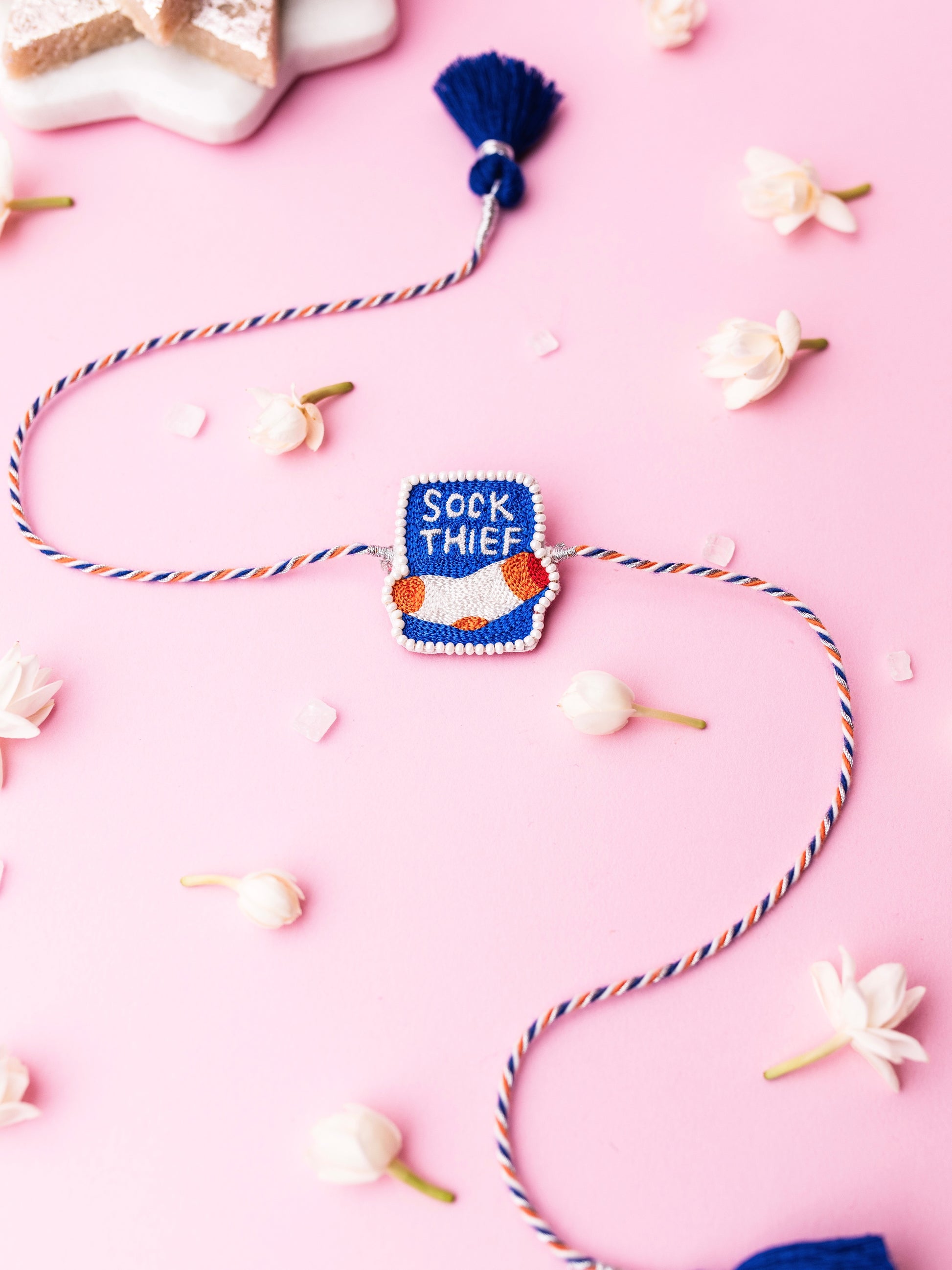Decorative pet rakhi with sock thief text 
