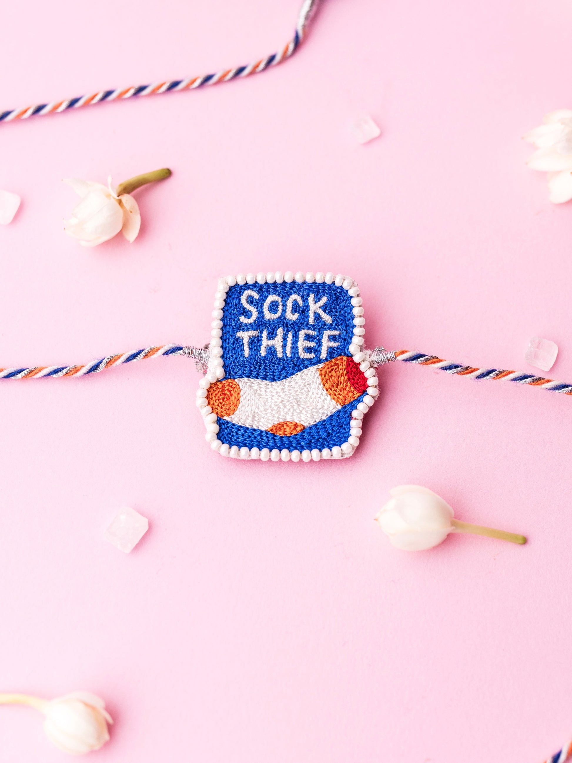 Decorative pet rakhi with sock thief text 