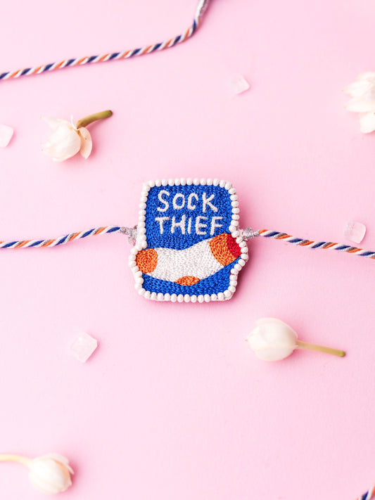 Decorative pet rakhi with sock thief text 