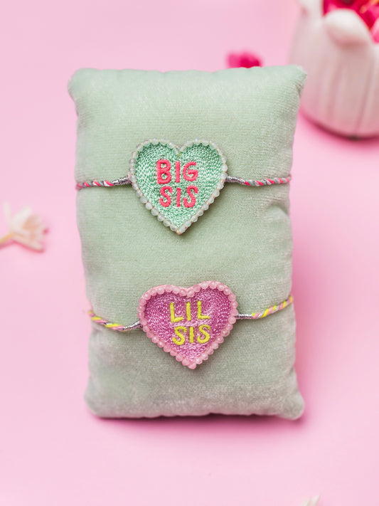Decorative sister rakhi with heart-shaped big sis and lil sis text