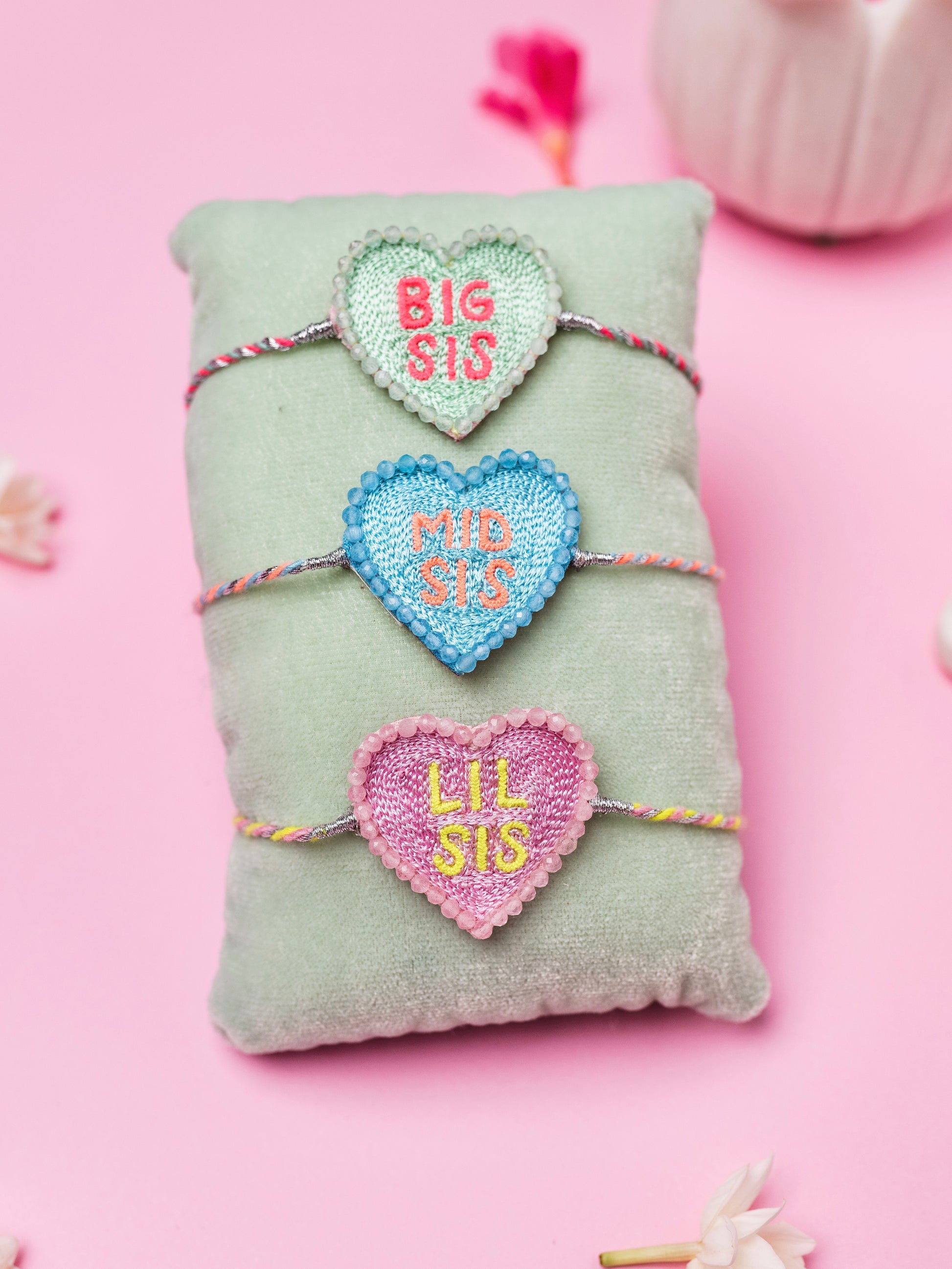 Decorative sister rakhi combo with heart-shaped big sis, mid sis and lil sis text